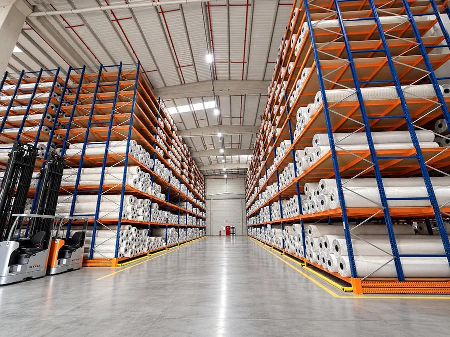 Forklift working between racks of finished rolls